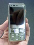 photo of the Nokia N82 mobile phone being held in a person's hand to show scale. The phone is narrower and shorter than the hand.