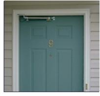 photo of a green door with an door opener at the top.photo of a green door with an door opener at the top.
