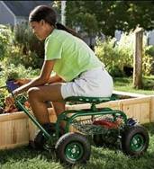 photo of a woman sitting on a Scoot-N-Do Caddy working at a raised bed.